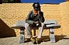 A portrait of Bongani Madondo. He sits in a chair, resting his face on one hand.