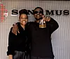 Christine “Seven” Mosha stands (L) smiling beside Nyashinski as they pose in front of a Sony Music backdrop.