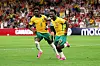 Two Australia players celebrate a goal on the pitch during a World Cup match.