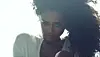 A screenshot from Tyla’s “Is It Love” video showing the singer in white and with full hair, staring into the camera.