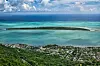 Aerial view of a tropical island lagoon near Mauritius with coastline and homes below.