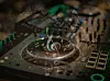 Close-up of a Pioneer DJ controller with lit buttons and a central jog wheel.