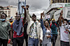Protesters raise their hands and chant during an anti-tax demonstration in downtown Nairobi.