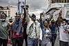 Protesters raise their hands and chant during an anti-tax demonstration in downtown Nairobi.