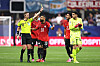 The referee stands with the Egyptian players in red-and-yellow soccer uniforms on the field.