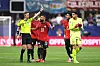 The referee stands with the Egyptian players in red-and-yellow soccer uniforms on the field.