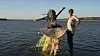 Hiba and Sally Elgizouli are standing in the Nile River, laughing, with Hiba wearing an elaborate, colorful costume.