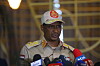 Mohamed Hamdan Dagalo speaks at a press conference in Khartoum with several microphones in front of him.