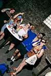 Group of people holding drinks and posing at a Martell event beside a brick wall.