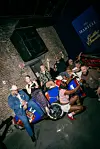 Group of guests posing in a Martell-branded lounge with blue seating and event signage.