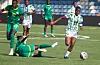 Women’s soccer players from Nigeria and Senegal challenge for the ball on a grass pitch during an international friendly.