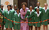 Oprah Winfrey and schoolgirls stand behind a ribbon at a school opening in Johannesburg.