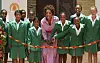 Oprah Winfrey and schoolgirls stand behind a ribbon at a school opening in Johannesburg.