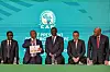 CAF officials stand onstage during a press conference, the CAF logo behind them.