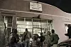 People stand in front of Niki’s Oasis in Newtown at night.