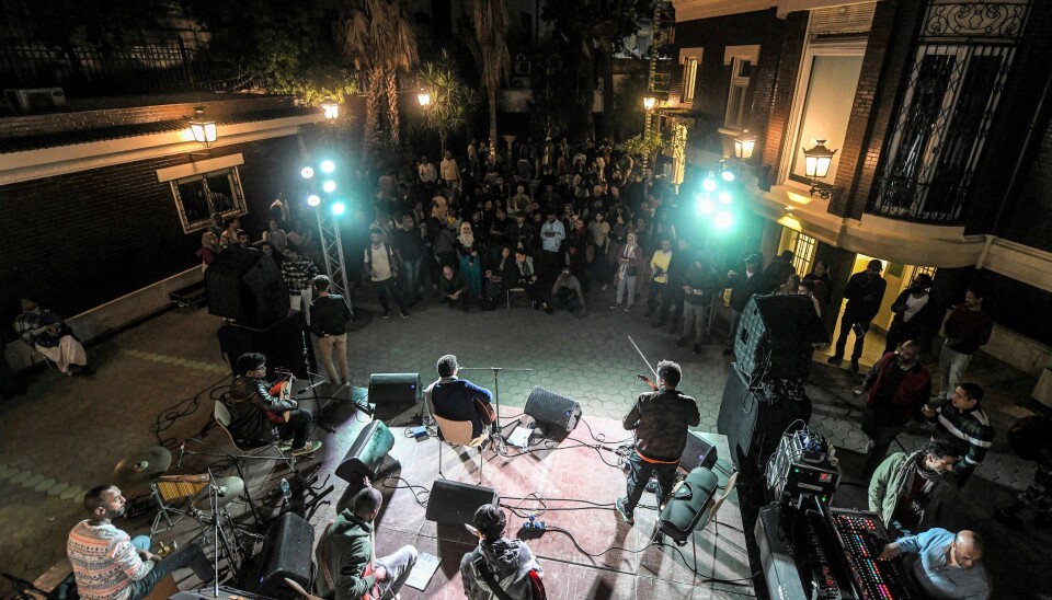 Band performs on an outdoor stage before a crowd at night in Cairo.