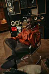 Nigerian producer Sarz in sunglasses and a leather jacket reclining among vintage speakers.