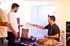 A photo of a man handing over a vinyl record to another  man.