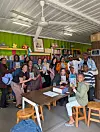 A group of travelers and local participants pose together, holding copies of Trevor Noah’s Born a Crime.
