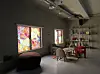 Industrial room with colorful stained-glass windows, lounge seating, and a dining area.