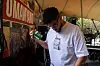 Benjamin Jephta in a white shirt adjusts equipment beside a mural at an outdoor venue.