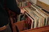 A person is looking through a stack of vinyl records under the section “Minimal.”