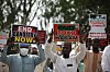 Masked protesters hold signs reading “End banditry now” and “Boko Haram” at a Katsina rally.