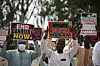 Masked protesters hold signs reading “End banditry now” and “Boko Haram” at a Katsina rally.