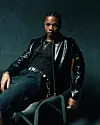 KiDi photographed in front of a black background wearing black top and pants and a black leather jacket