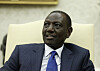 Kenyan President William Ruto sits in a cream-colored chair during a White House meeting.