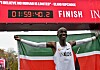 Eliud Kipchoge raises his arms beneath a finish clock showing 1:59:40.2.