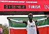 Eliud Kipchoge raises his arms beneath a finish clock showing 1:59:40.2.