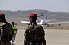 Two uniformed Ethiopian forces members stand near a relief cargo plane at Mekelle airport.