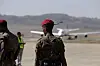 Two uniformed Ethiopian forces members stand near a relief cargo plane at Mekelle airport.