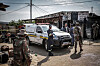 Uniformed officials and forensic personnel gather beside a white vehicle outside a Johannesburg bar.