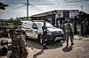 Uniformed officials and forensic personnel gather beside a white vehicle outside a Johannesburg bar.