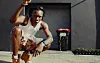 Blaqbonez crouches low on a paved street in the visualizer for his diss track “ACL,” aimed at ODUMODUBLVCK.