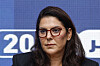 Fatima Ezzahra El Mansouri wearing glasses at a press conference against a blue backdrop in Rabat.