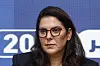 Fatima Ezzahra El Mansouri wearing glasses at a press conference against a blue backdrop in Rabat.