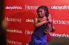 An image of Gyakie on a red carpet with a custom Hennessy bottle.