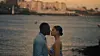 A man and woman stand close together at sunset in a still from the romantic comedy 'East West Love.'