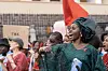 Eliane Umuhire as Queen raises her fist and shouts during a street protest.