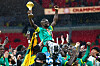 Senegal players raise the Africa Cup of Nations trophy amid confetti and cheering supporters.