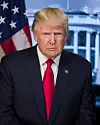President Donald Trump looking straight ahead, an American flag behind him.