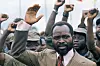 Samora Machel gestures before a crowd of supporters, many with raised fists, in Maputo.