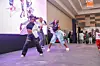 A group of dancers in K-Pop-inspired outfits performs on stage at the Nairobi Comic-Convention, featuring synchronized moves and energetic poses.