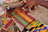 GHANA - 2009/11/28: Man weaving kente textile stripe using a traditional loom.