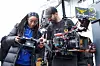 Emily Nkanga and Rick Joaquim looking into the camera display on the set of \u2018Yam & Egg.\u2019
