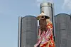 A still from the film of a man in a traditional Nigerian facemask standing in front of a building in Detroit.