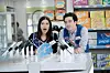 Actors from the sitcom Superstore wearing store uniforms and looking over a table of demontration phones for sale.